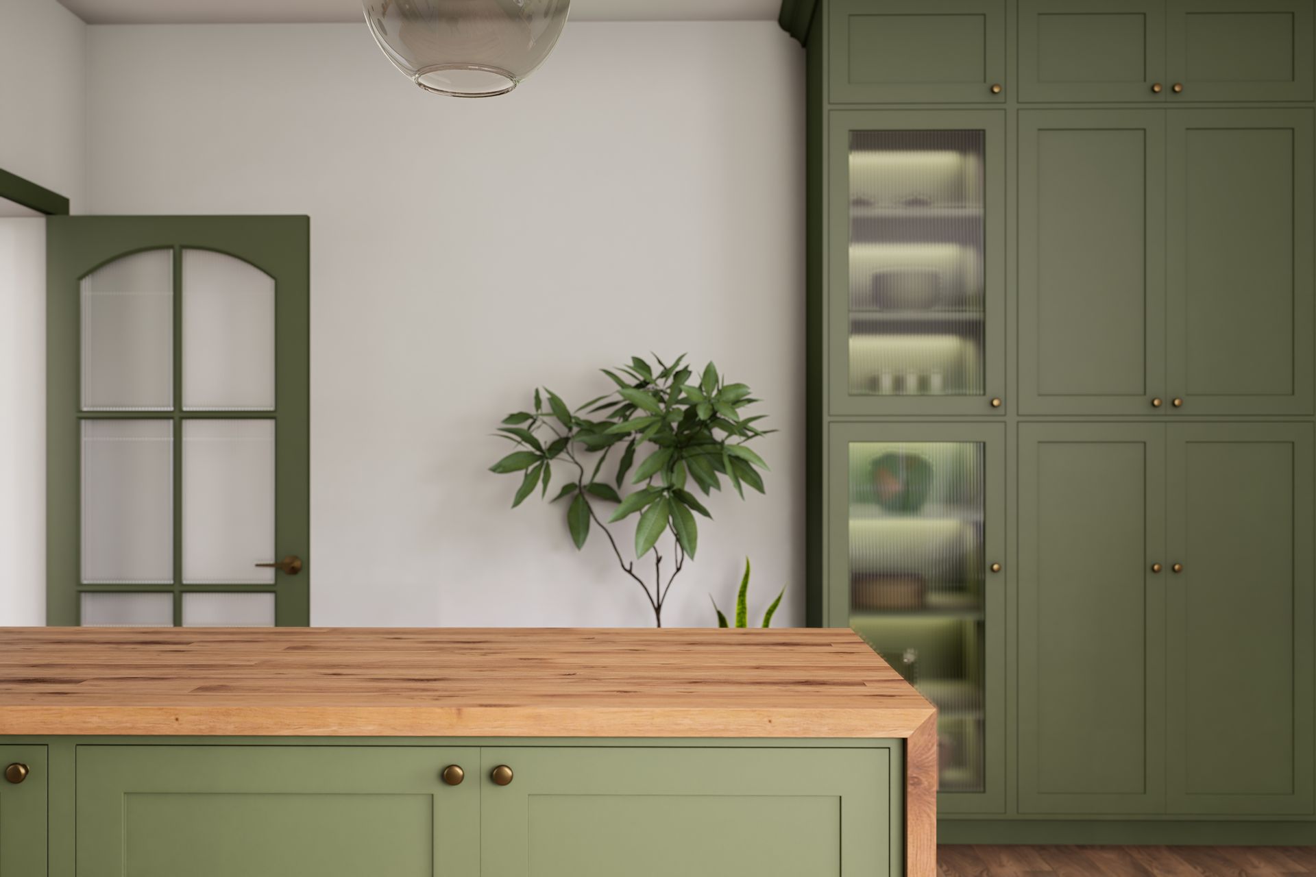 A kitchen island with a wooden countertop in front of olive-green cabinetry and an arched door with glass panels. A kitchen island with a wooden countertop in front of olive-green cabinetry and an arched door with glass panels.