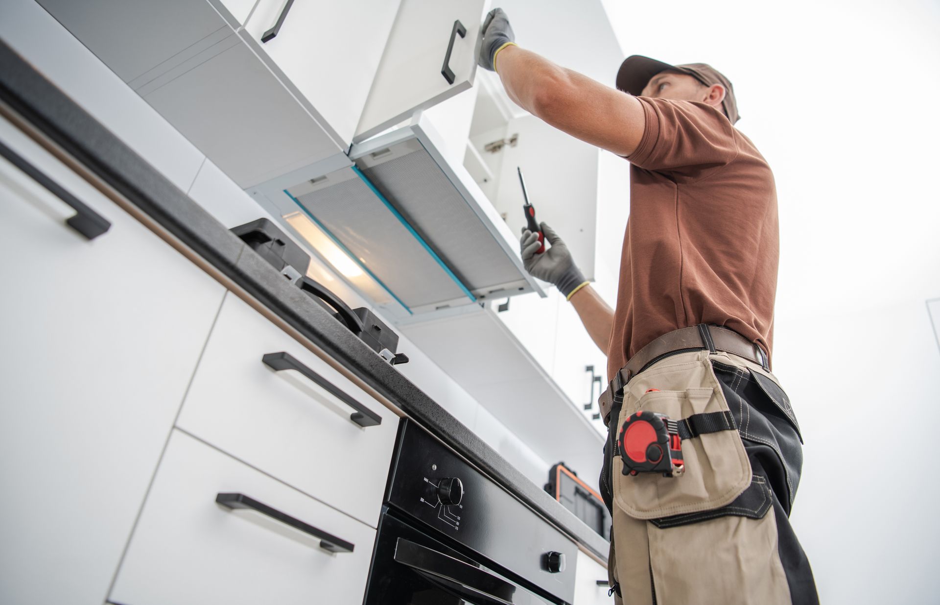 Residential Cabinetmaker Worker Finishing New Kitchen Installation 
