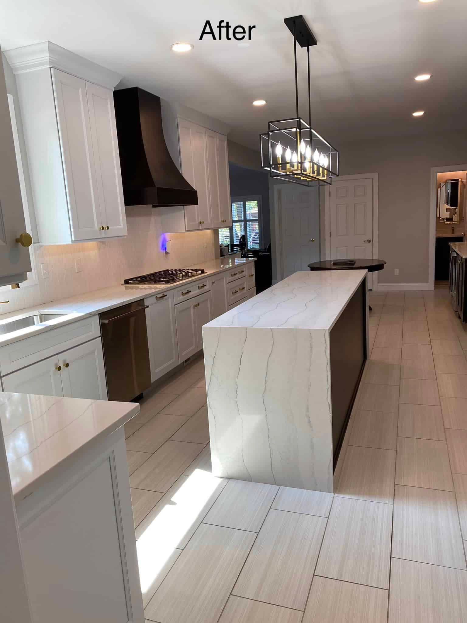 Bright modern kitchen with white island, gray cabinets, pendant lights, and stainless appliances Bright modern kitchen with white island, gray cabinets, pendant lights, and stainless appliances
