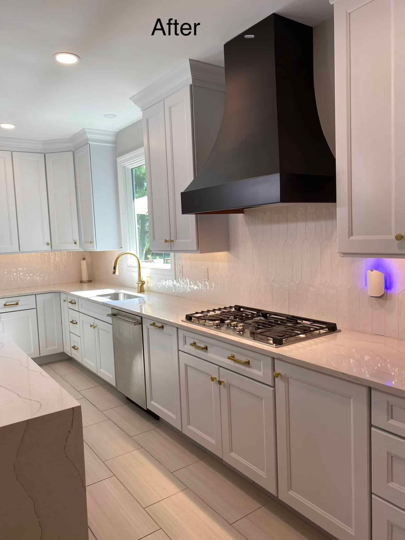 Bright white kitchen with gray cabinets, black range hood, marble countertops, and gas cooktop. Bright white kitchen with gray cabinets, black range hood, marble countertops, and gas cooktop.
