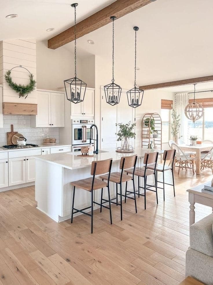 A kitchen with white cabinets, granite countertops, stainless steel appliances, and wood-look flooring.