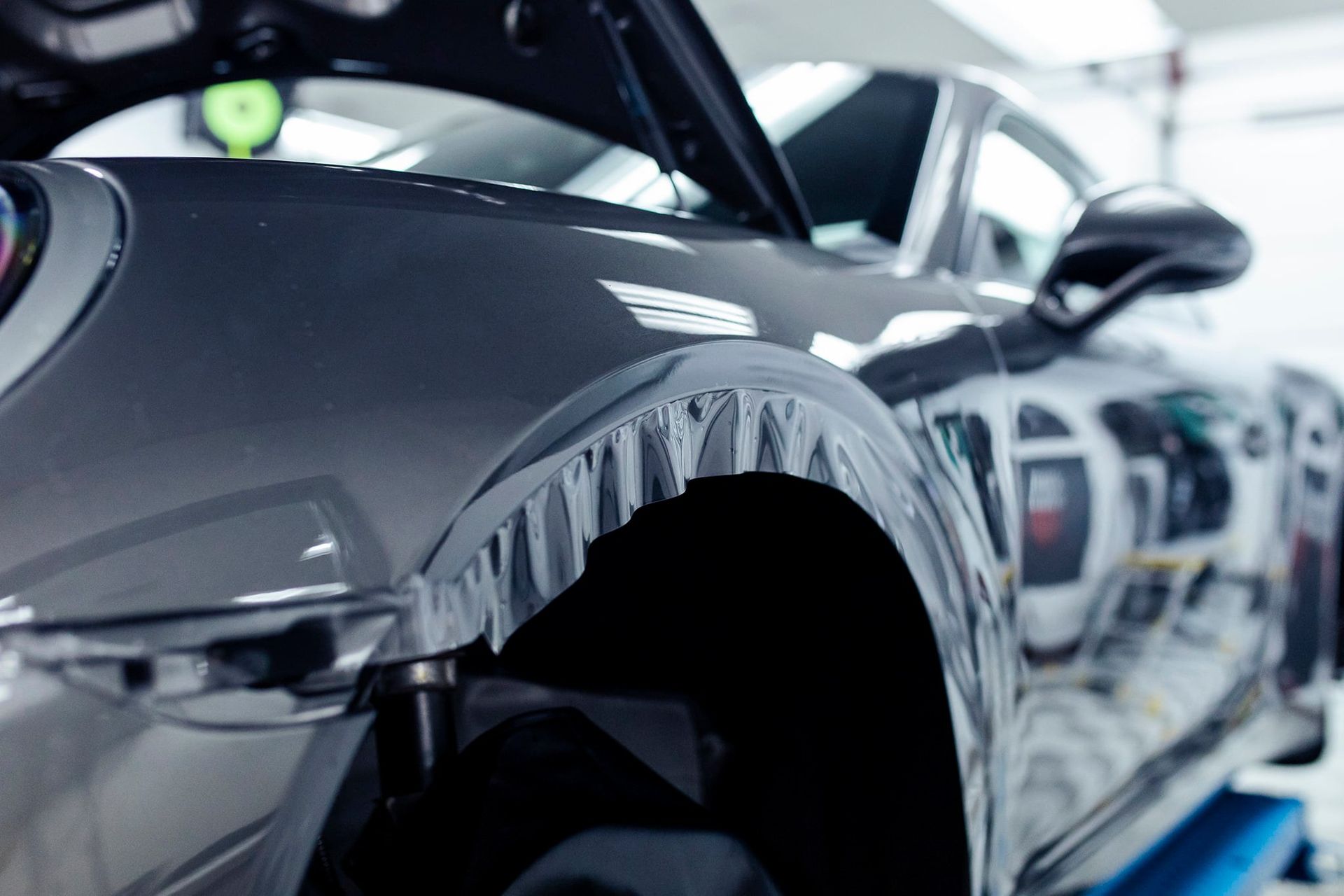 A close up of a car 's fender with wrapping tape on it.