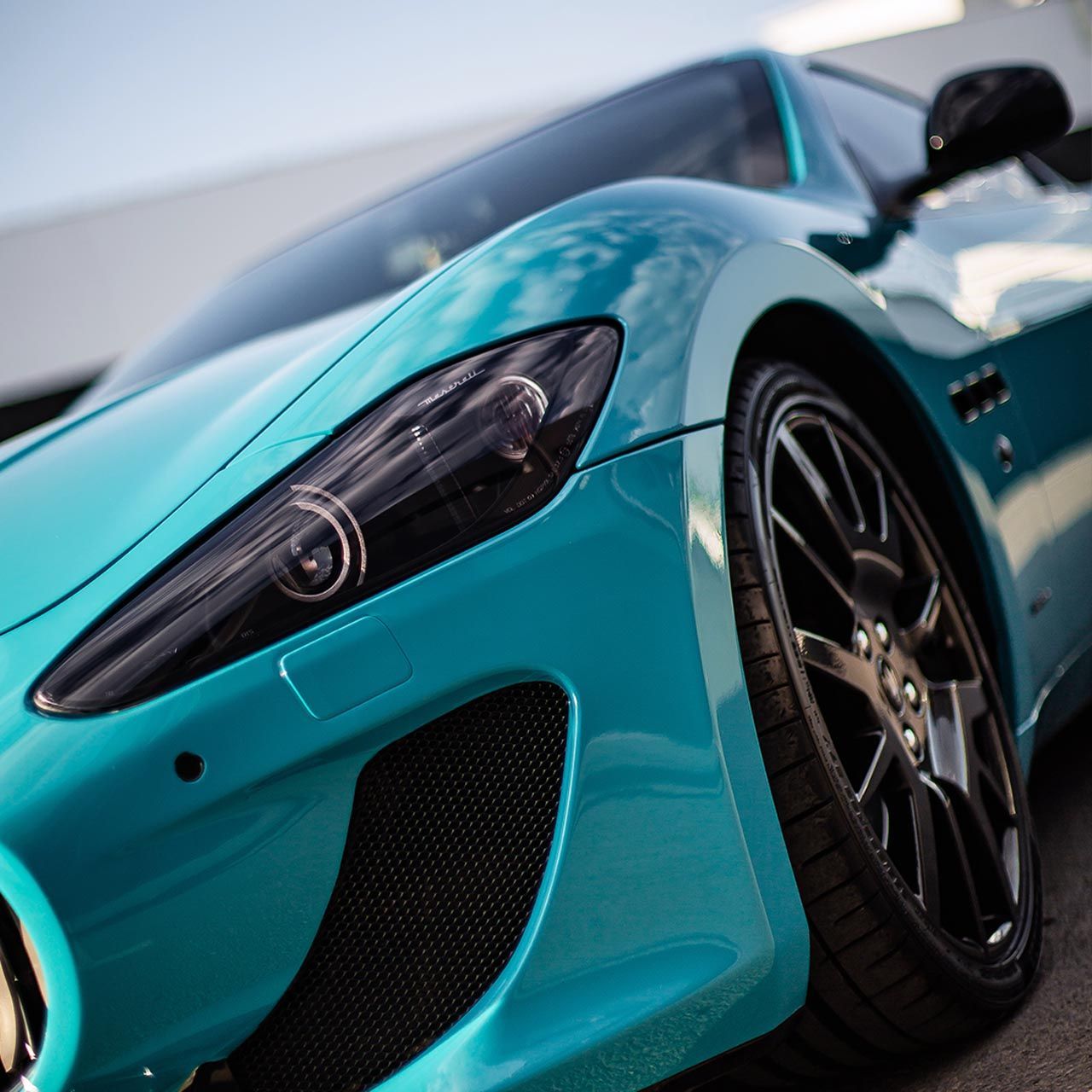 A close up of a car 's fender with wrapping tape on it.
