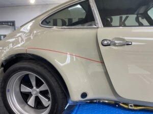 A white porsche is sitting on top of a blue table.