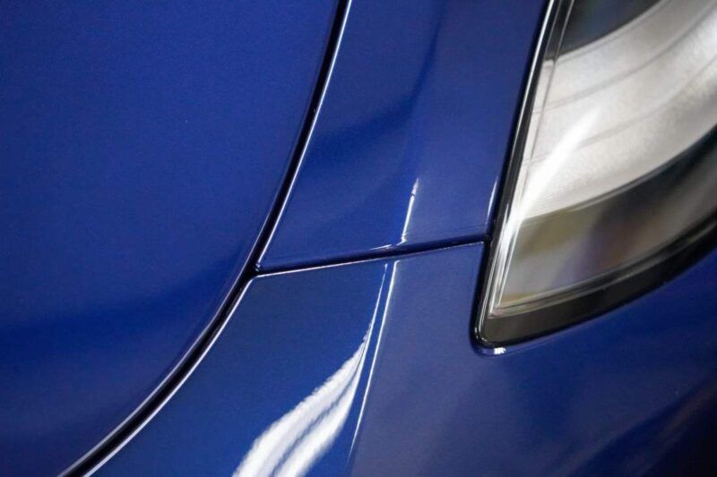 A close up of a blue car 's headlight