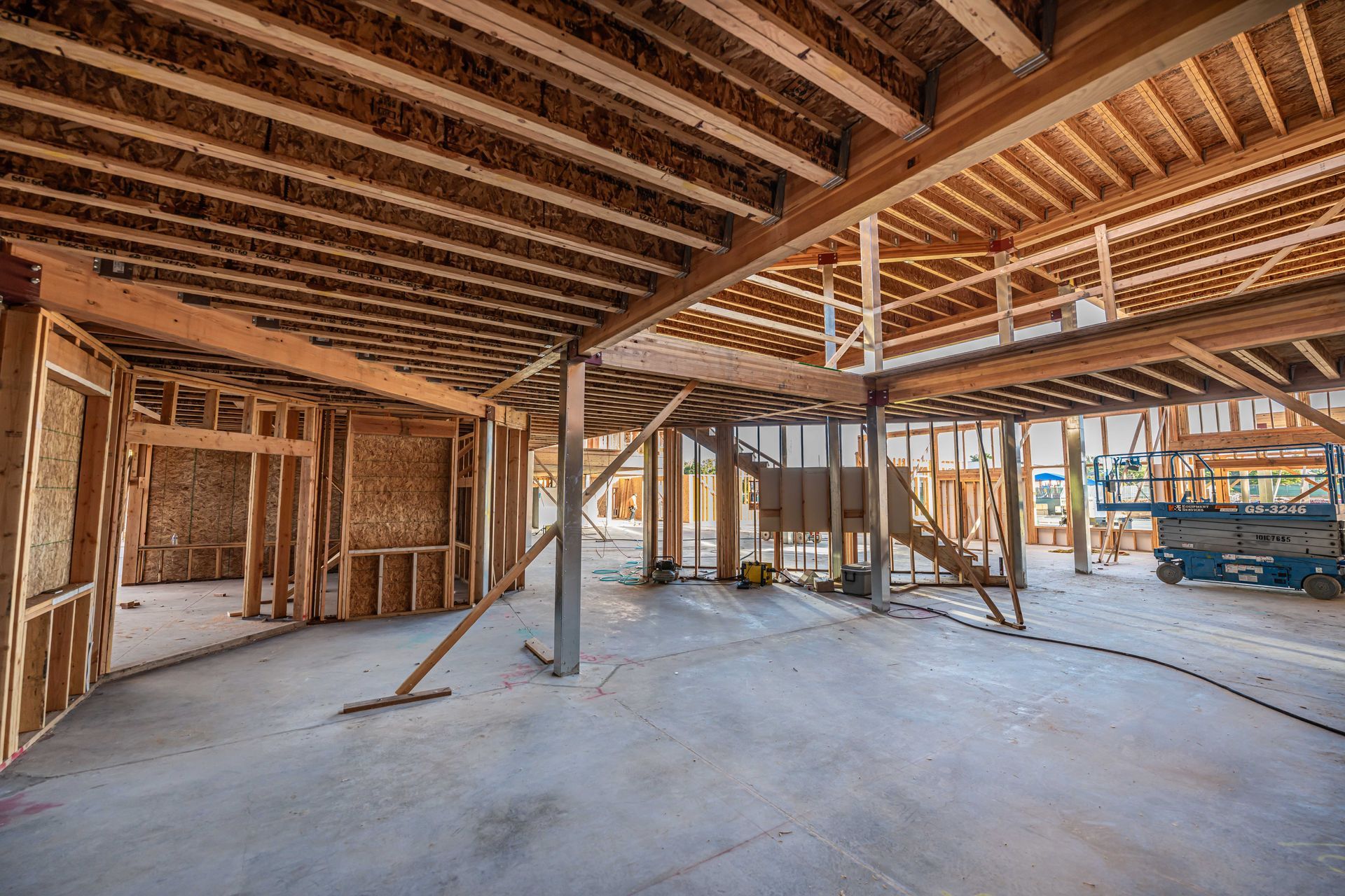 Unfinished interior of a wooden house under construction with exposed beams and framing