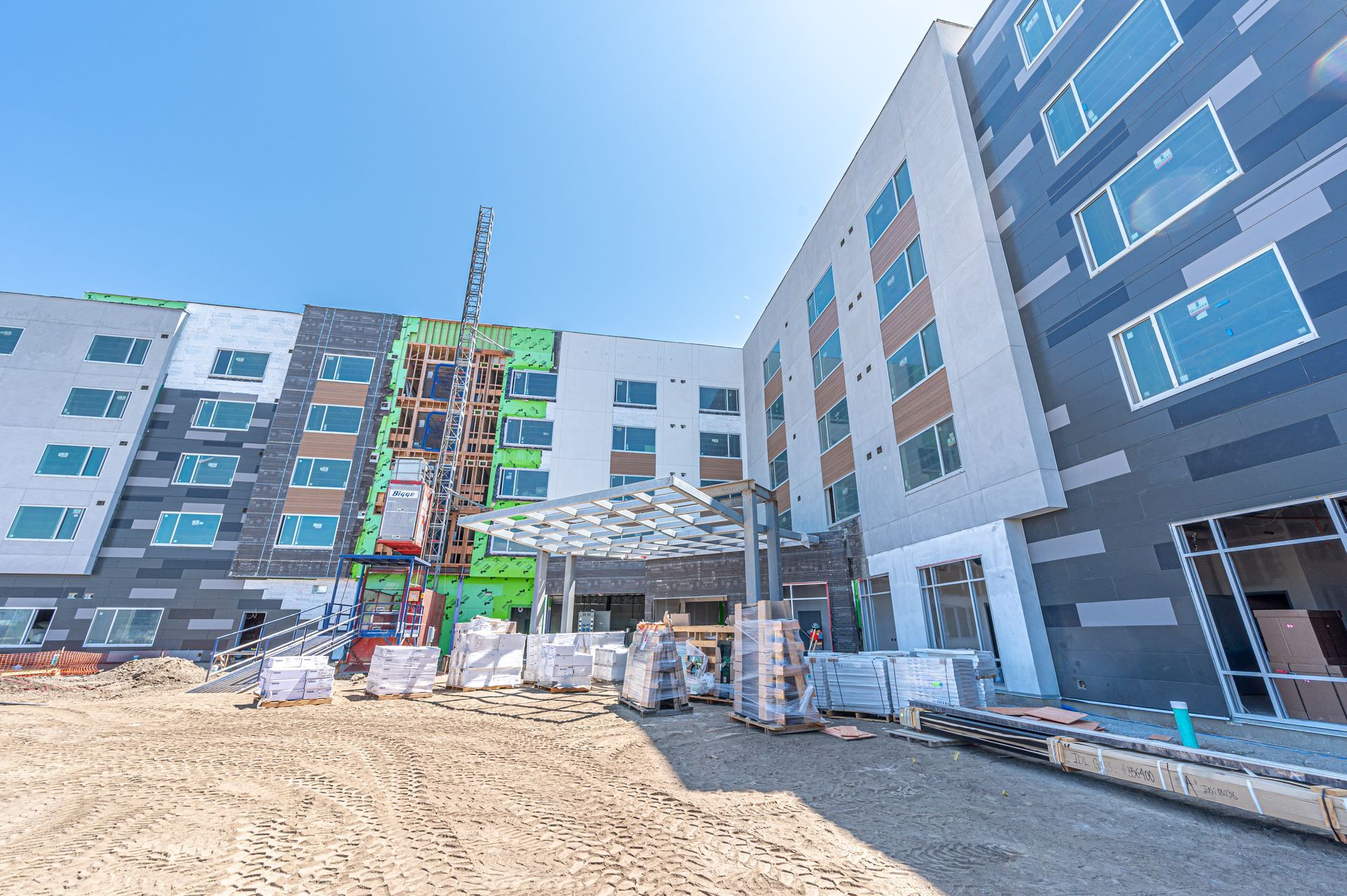 Construction site at a modern apartment building with scaffolding and a dirt foreground
