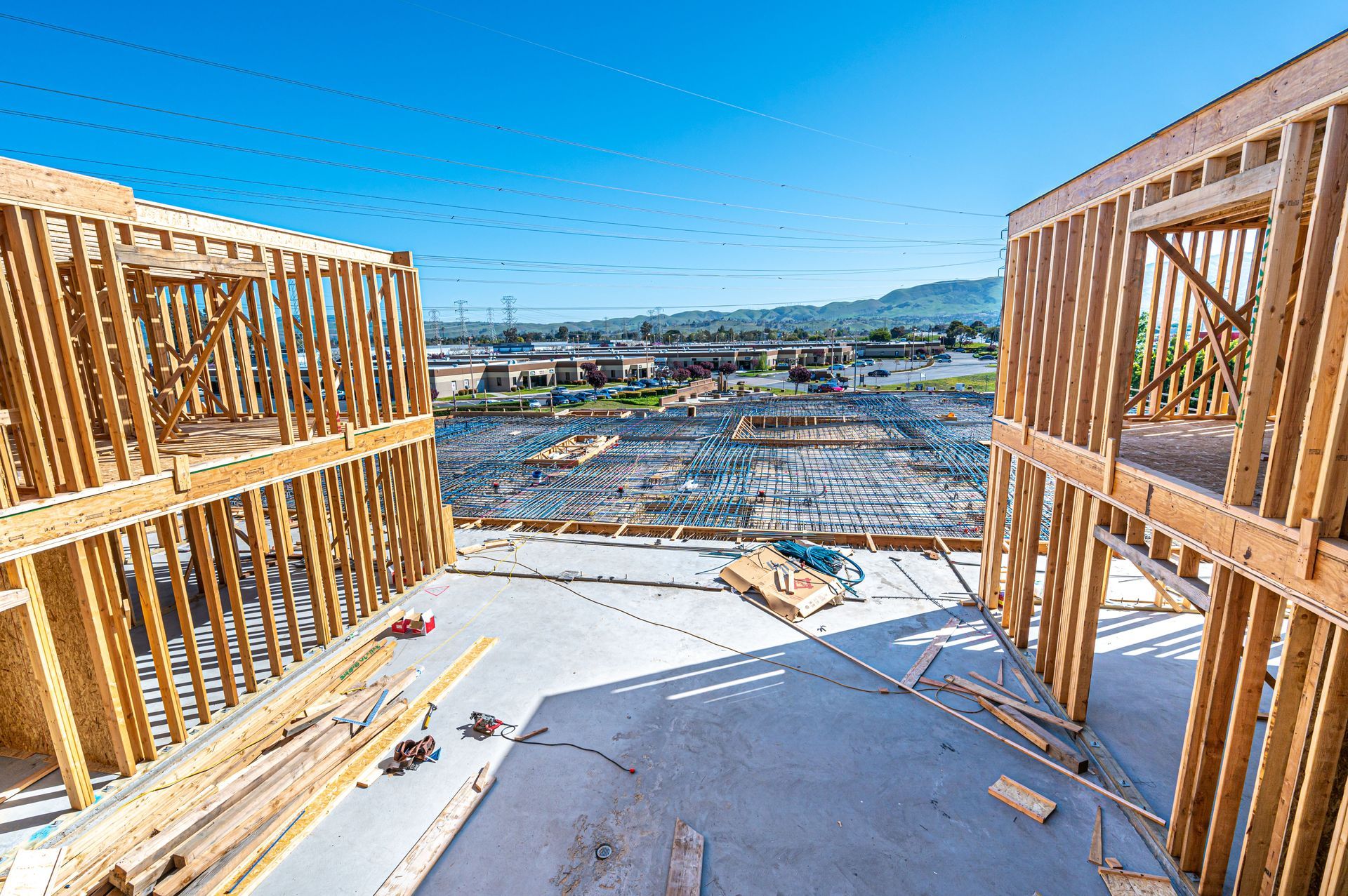 Construction site view from unfinished wooden framing overlooking a distant city and mountains