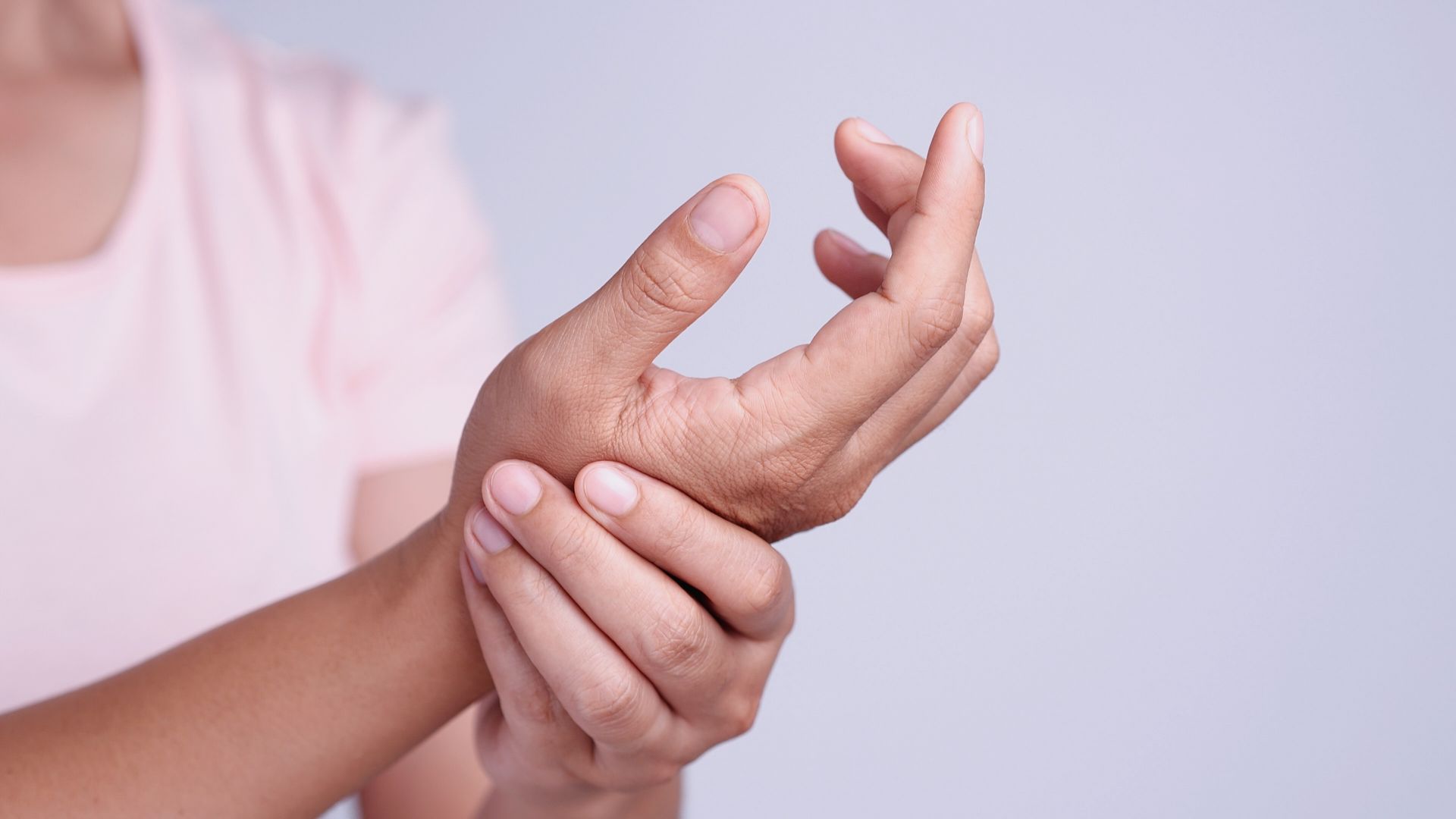 A woman is holding her wrist in pain.
