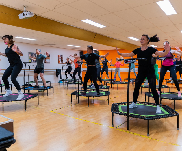 Een groep mensen springt op trampolines in een sportschool.