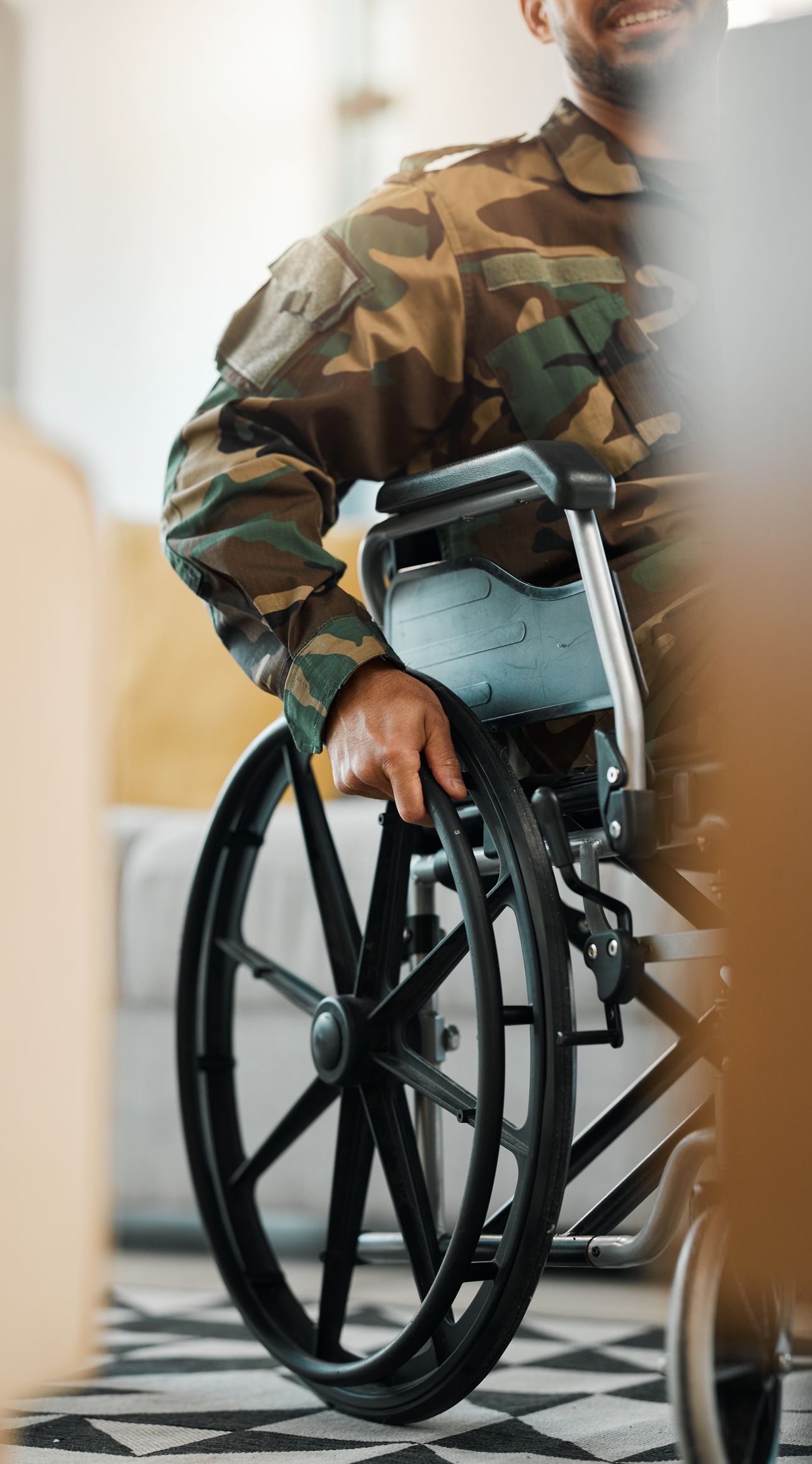 A soldier is sitting in a wheelchair in a living room.