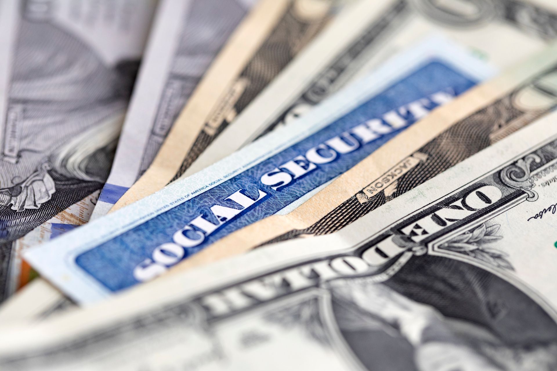 A pile of money with a social security card on top of it.