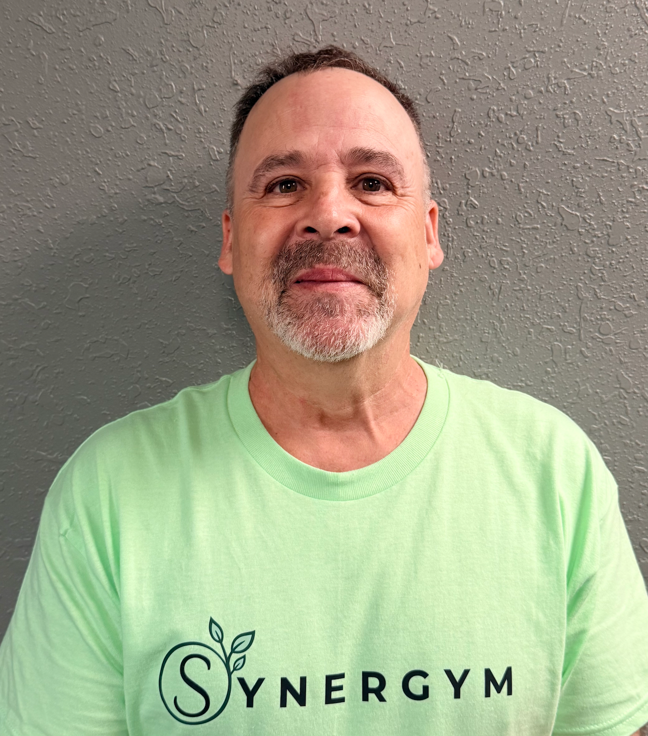 SynergyM logo with a green leaf and circular “Grow. Connect. Thrive.” design on a dark background