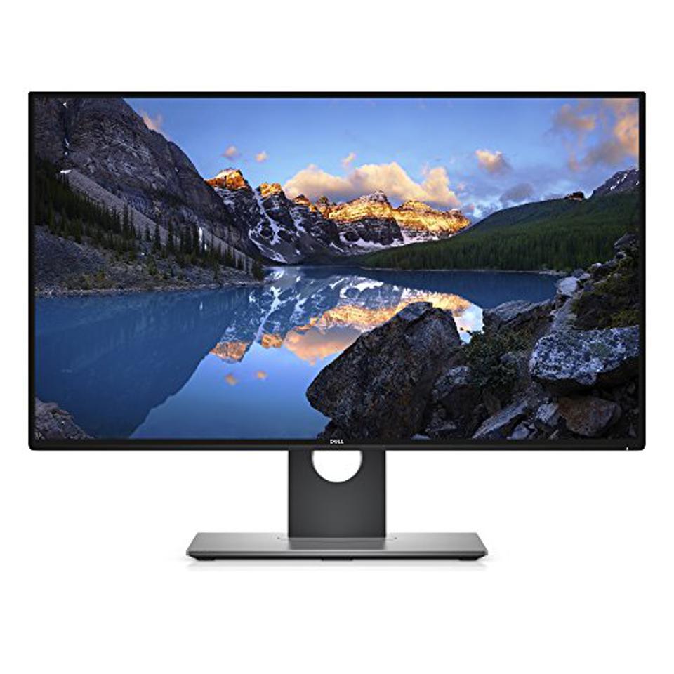 A dell computer monitor with a picture of a lake and mountains on it.