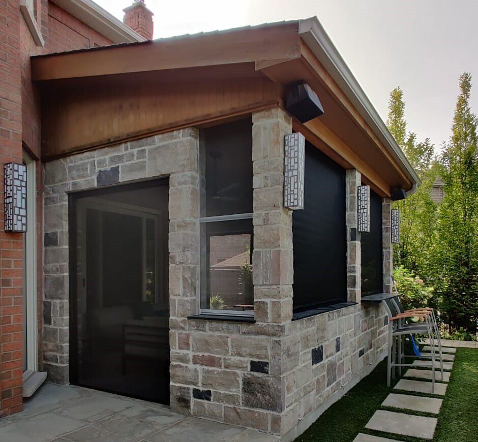 A brick building with a screened in porch and a speaker on the roof