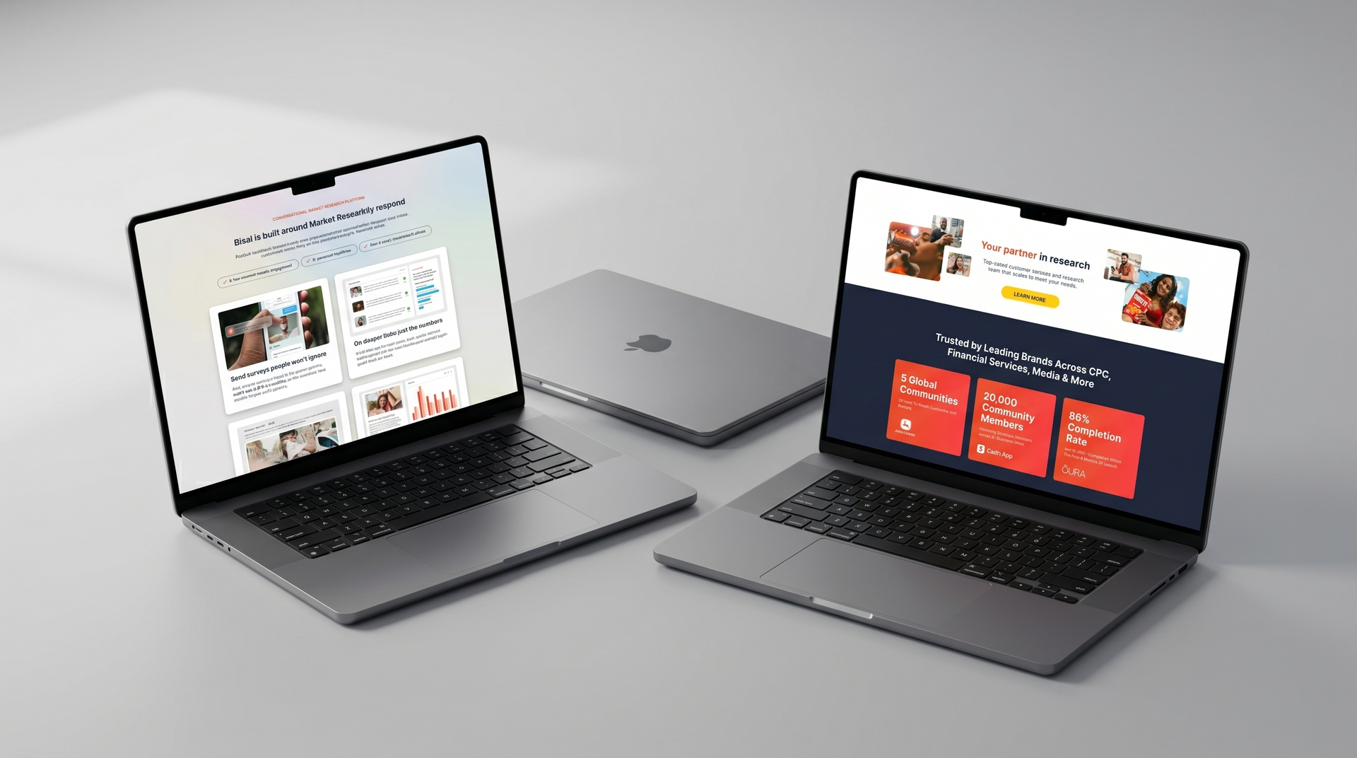 Two open laptops displaying websites on a gray tabletop, with a closed laptop centered behind them.