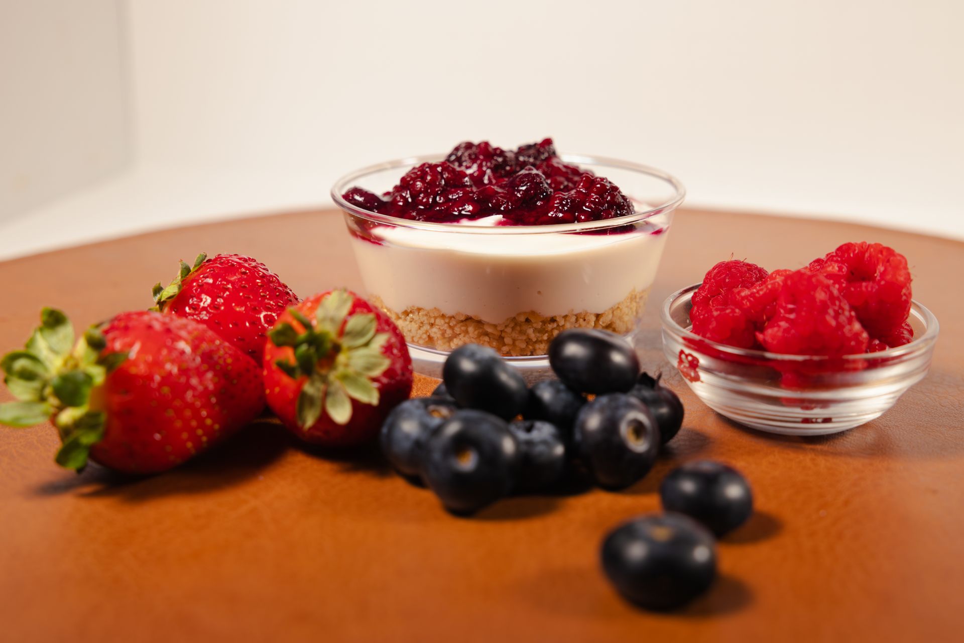 Assorted fresh berries with yogurt cups on a wooden table