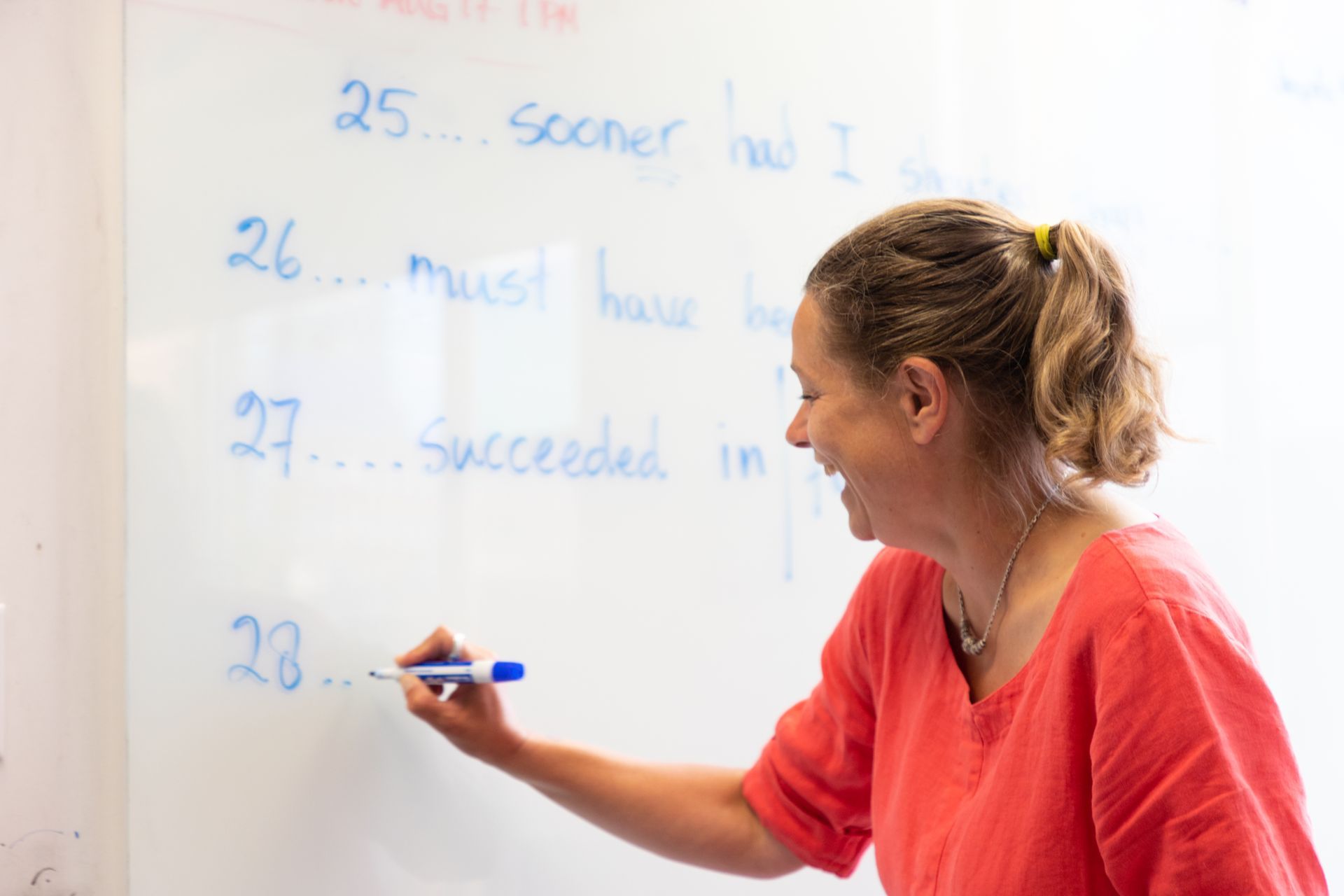 Woman writing on a whiteboard during a lesson
