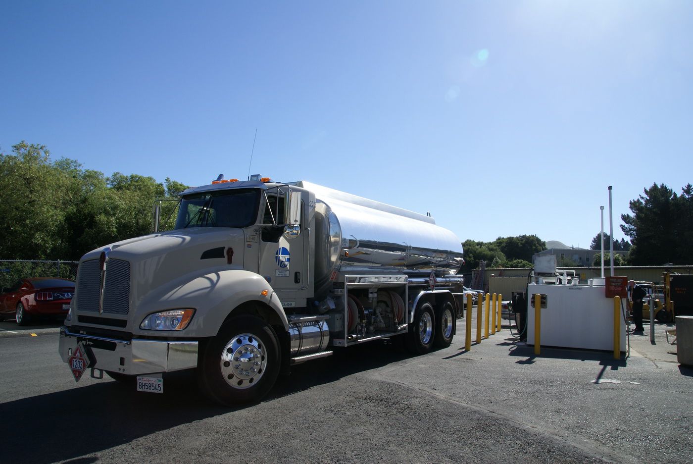 A large tanker truck is parked in a parking lot. A large tanker truck is parked in a parking lot.