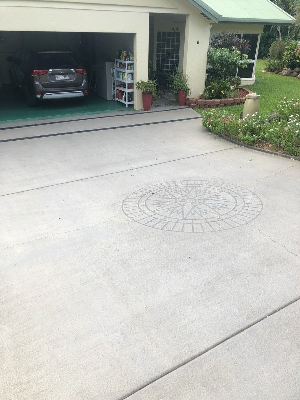 A car is parked in a garage in front of a house — Pete's Painting Solutions In Cairns, QLD