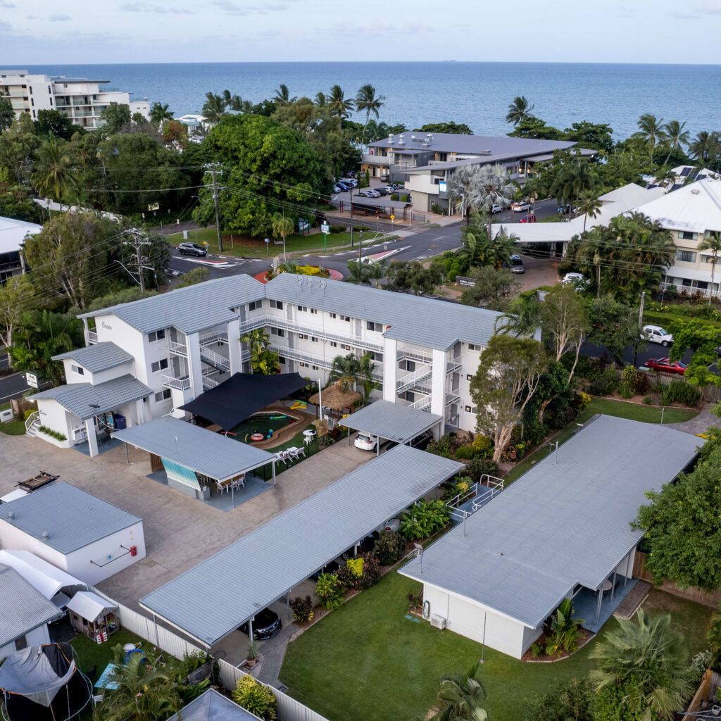 Aerial View of a Multi-story Hotel and Carports Near a Beach and Ocean — Pete's Painting Solutions In Cairns, QLD