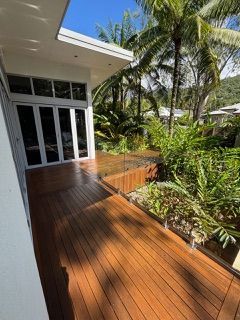 Wooden Deck With Glass Railing Overlooks Lush Garden — Pete's Painting Solutions In Cairns, QLD
