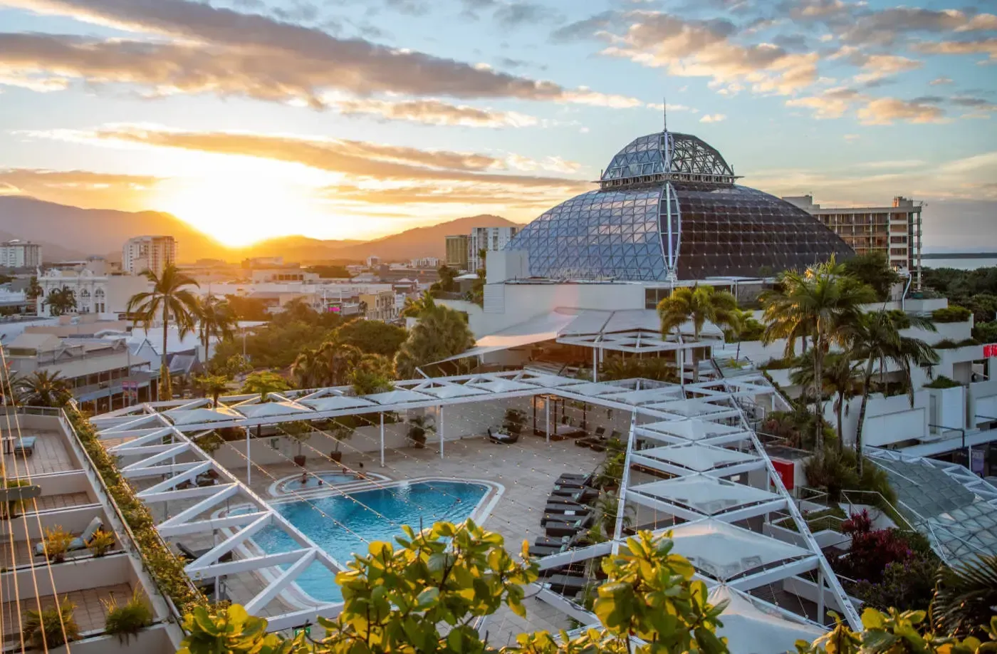 Sunset Over a Hotel With a Pool and Large Glass Dome Structure — Pete's Painting Solutions In Cairns, QLD