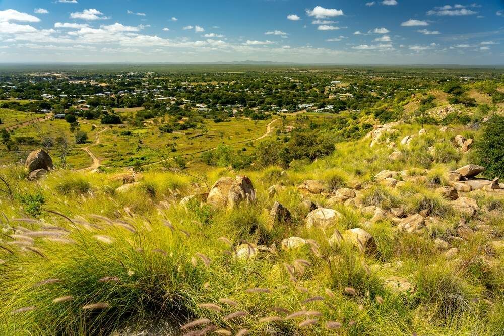 A View Of A Lush Green Field With A Small Town In The Distance — Pete's Painting Solutions In Mount Sheridan, QLD