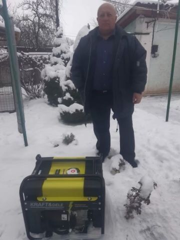 Man Standing Next to a Yellow and Black Generator in a Snow-covered Yard — Pete's Painting Solutions In Cairns, QLD