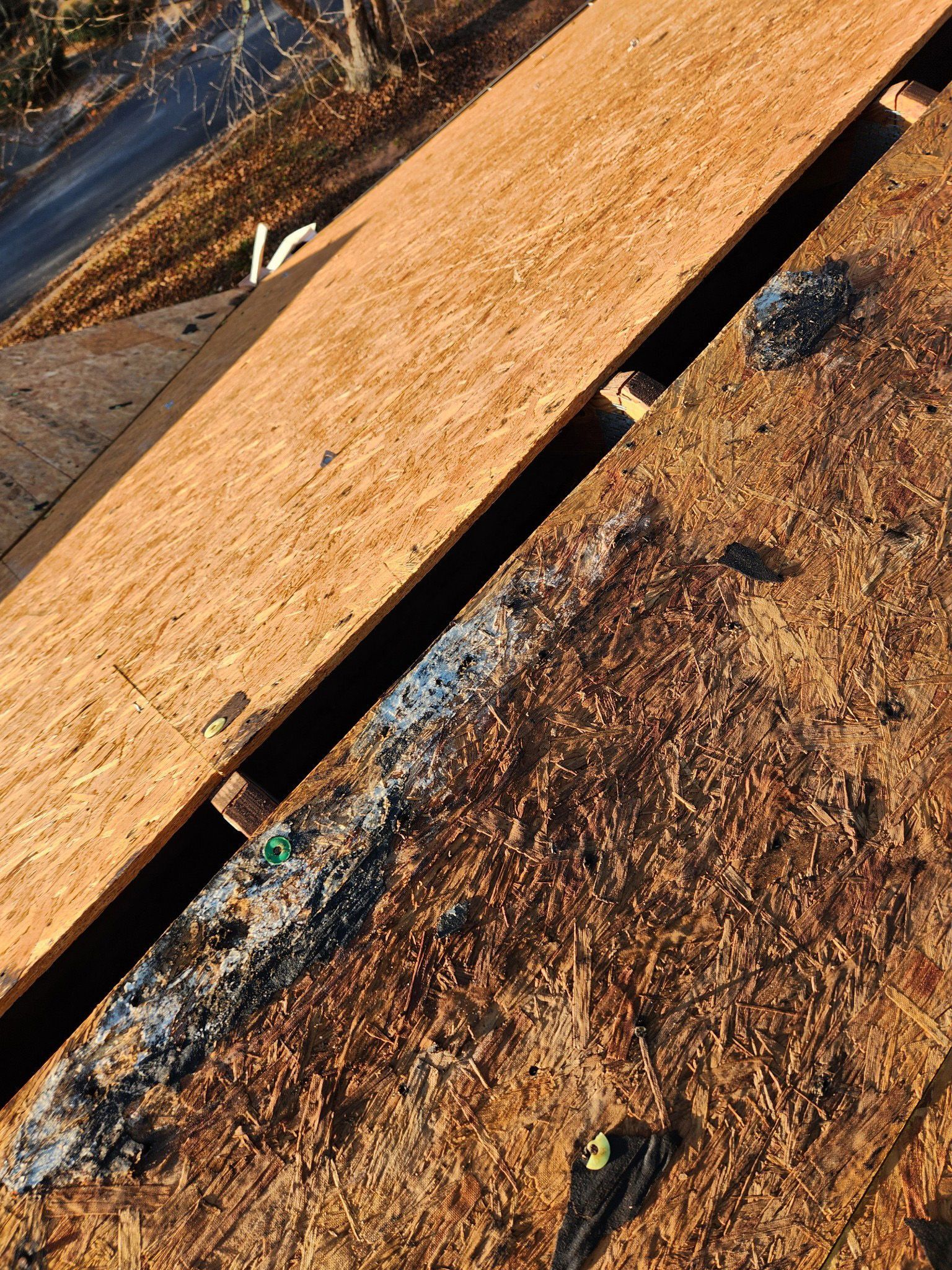 Rooftop with exposed wood and a narrow gap, contrasting new wood and aged surface.