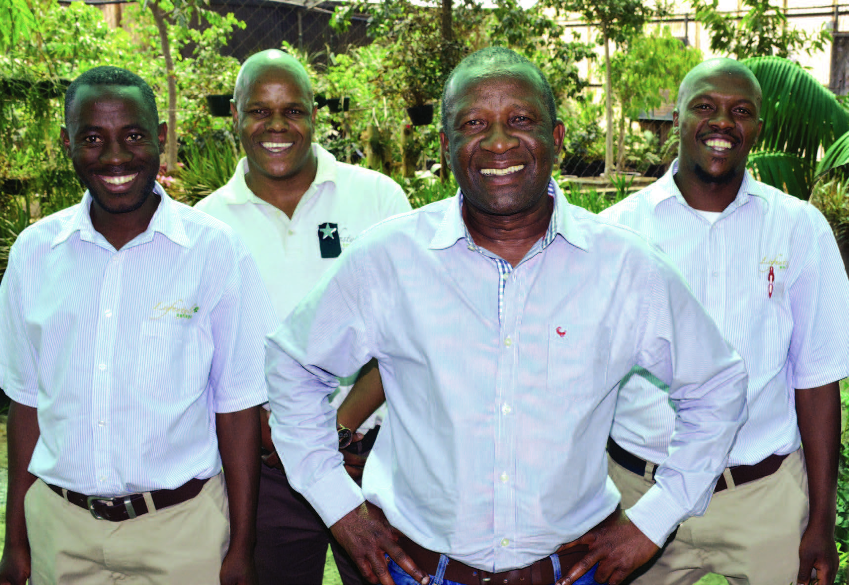 four professional men standing in a nursey garden