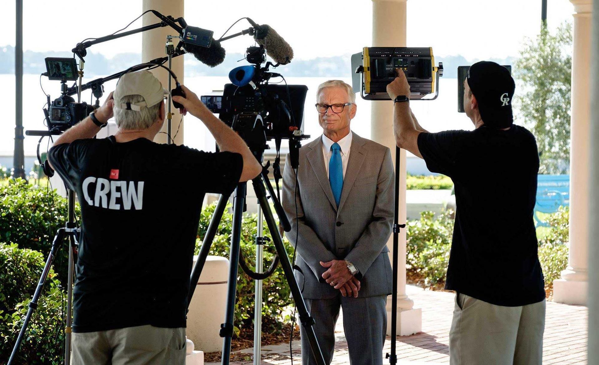 A man in a suit and tie is being interviewed by a crew member