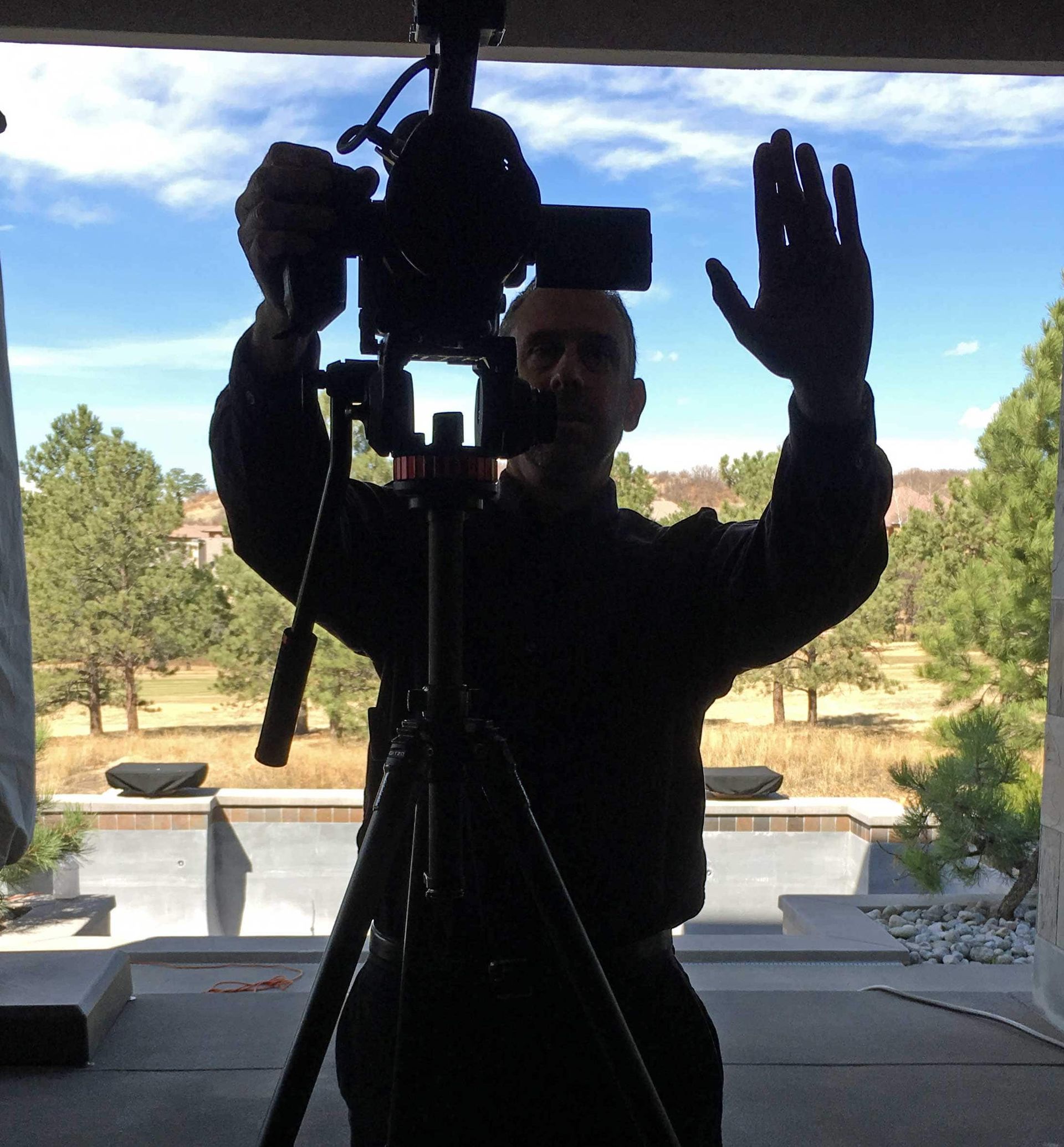 A man is standing in front of a camera on a tripod