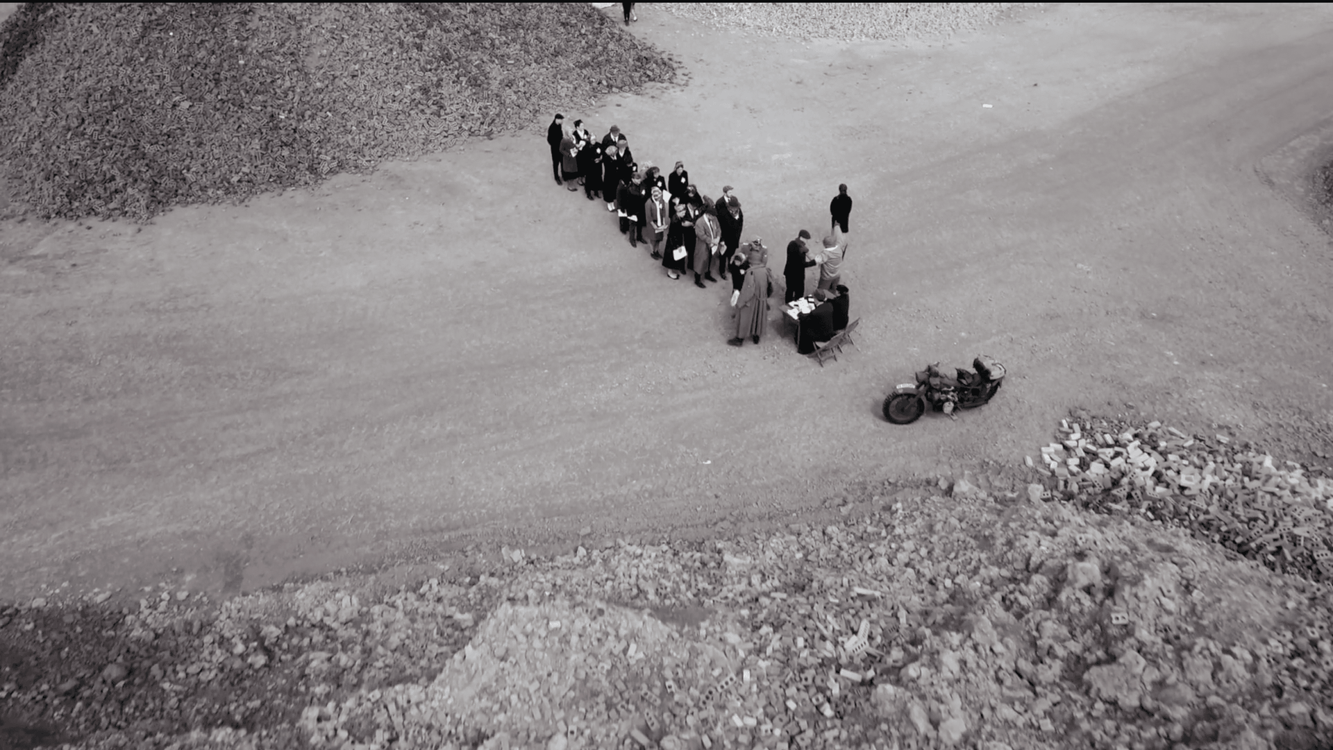 A black and white photo of a group of people standing in a line