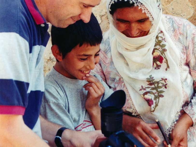 A man and a woman are looking at a camera