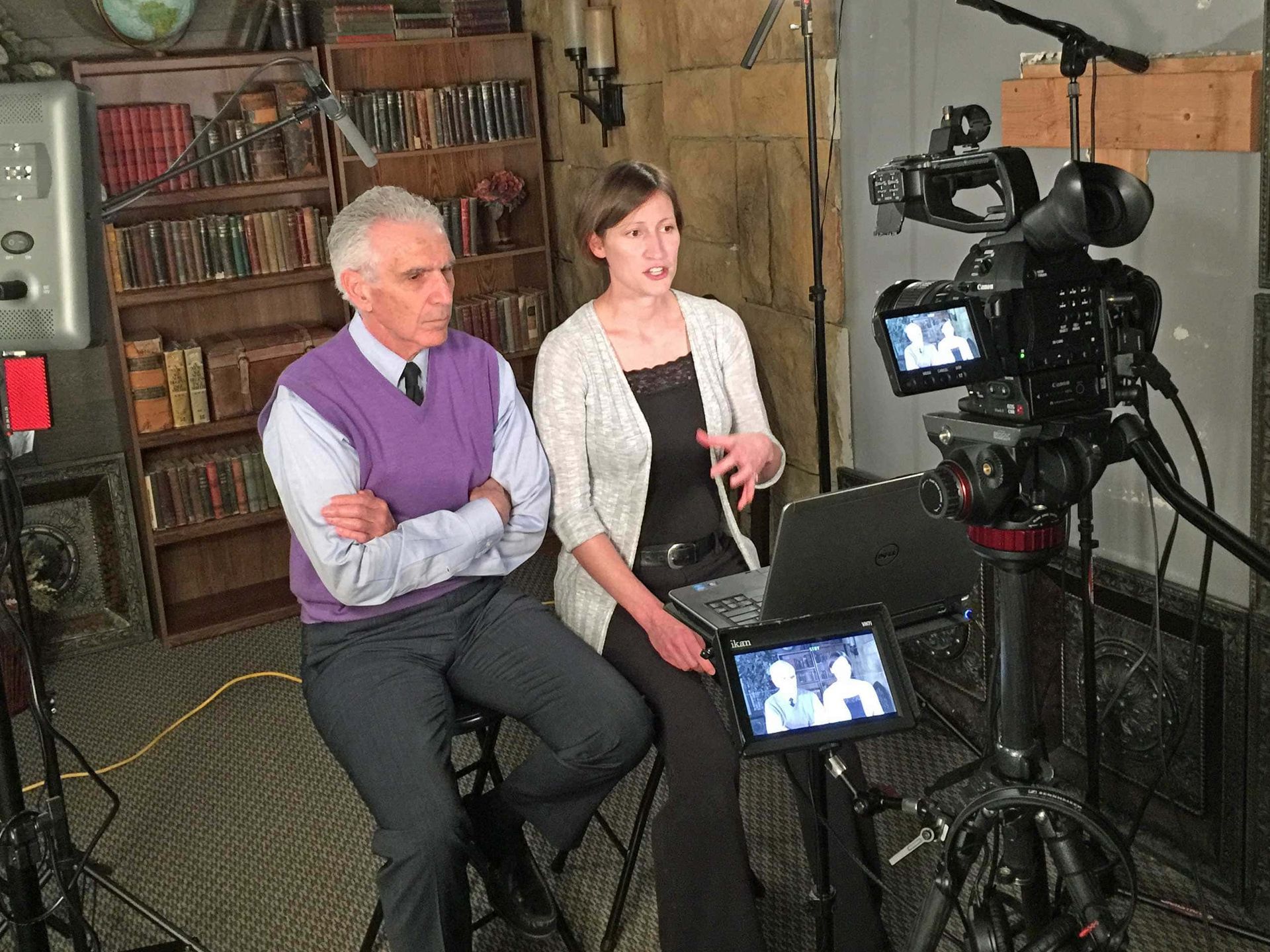 A man and a woman are sitting in front of a camera
