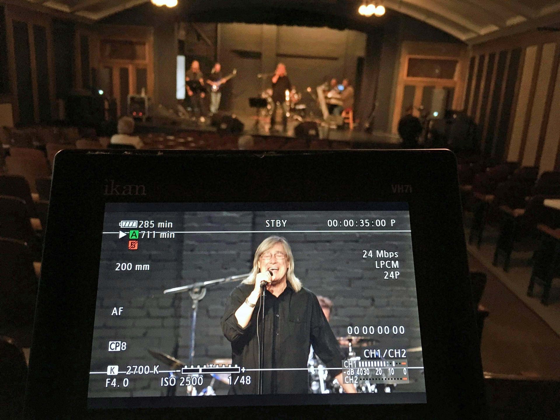 A woman singing into a microphone on a tablet screen