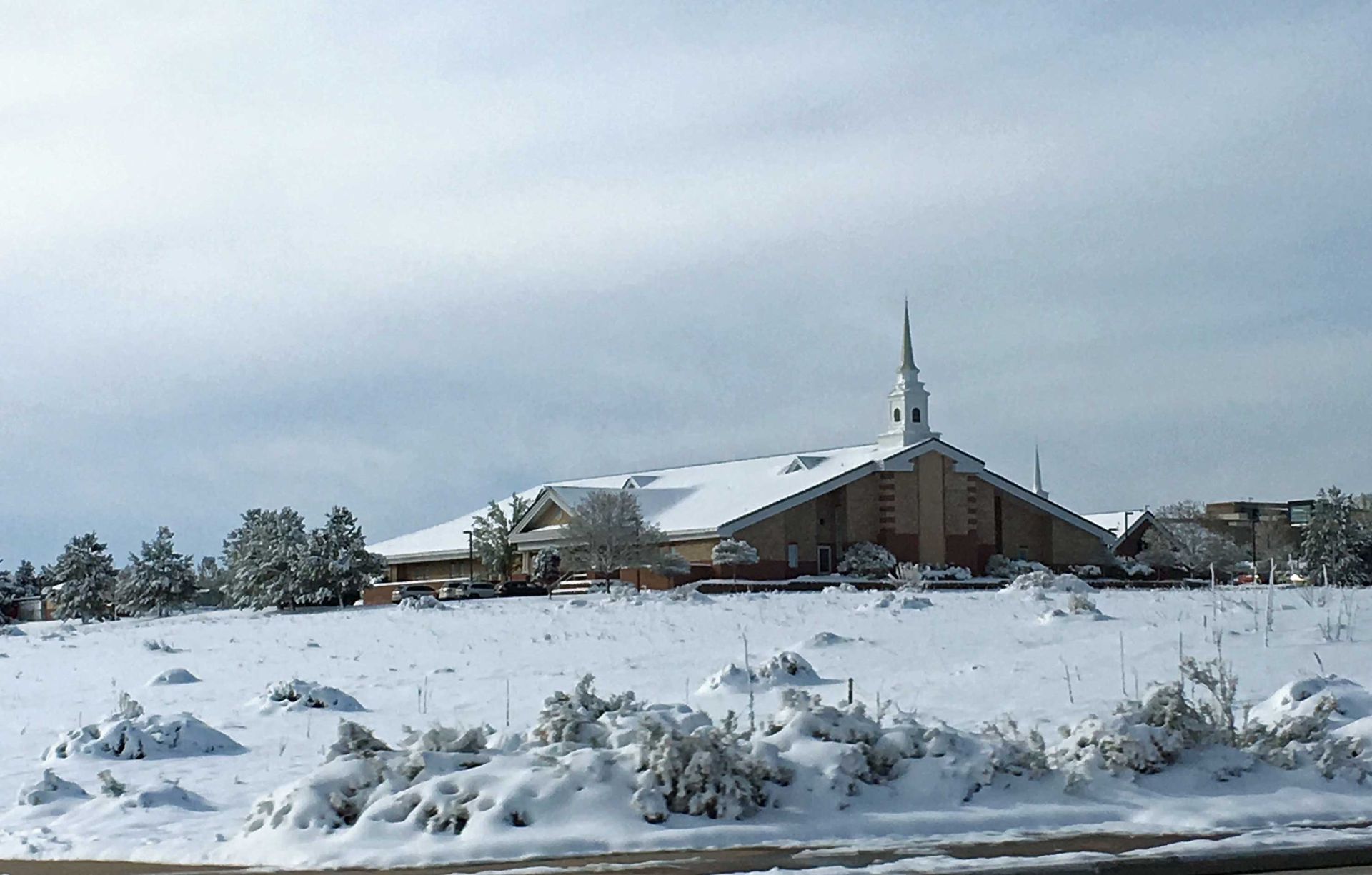 A church in the middle of a snow covered field.