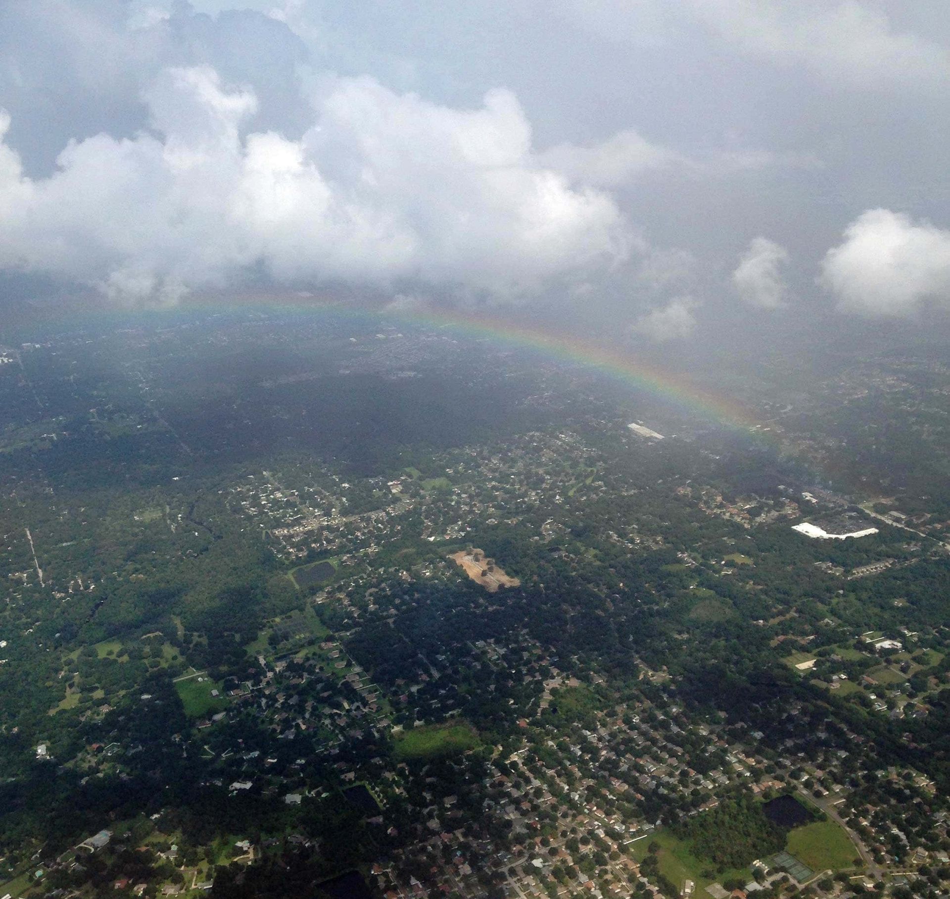 An aerial view of a city with a rainbow in the sky