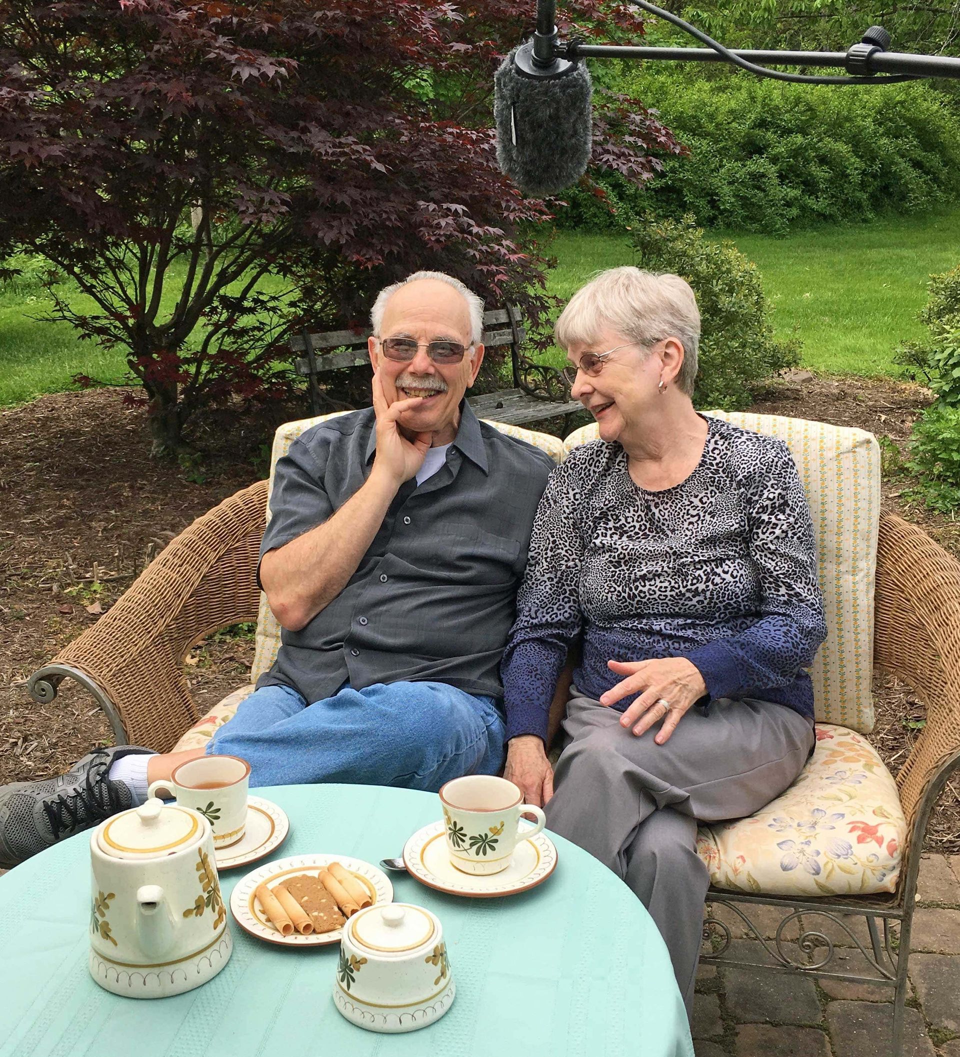 A man and a woman are sitting at a table with plates of food.