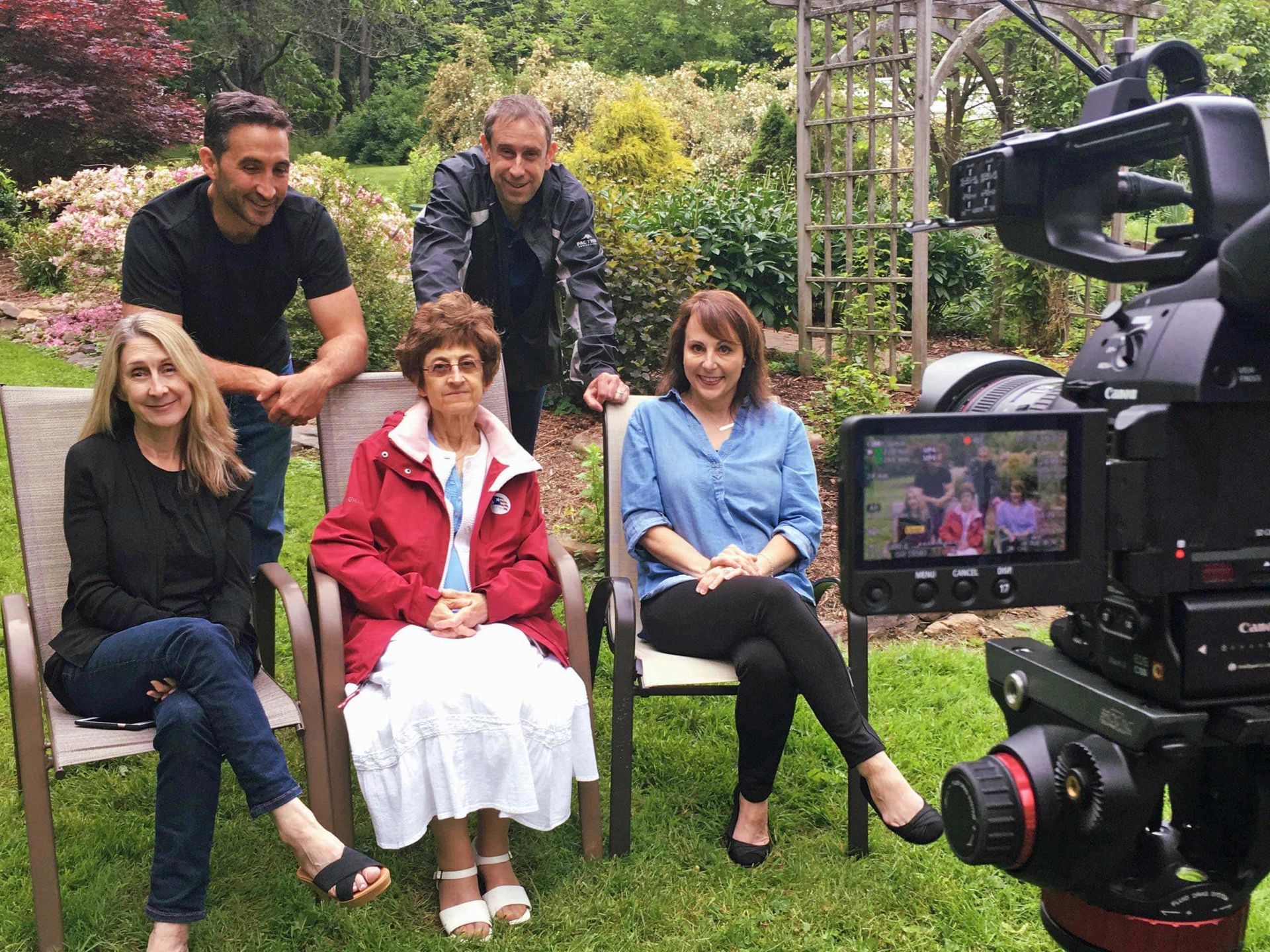 A group of people are sitting in chairs in front of a camera.