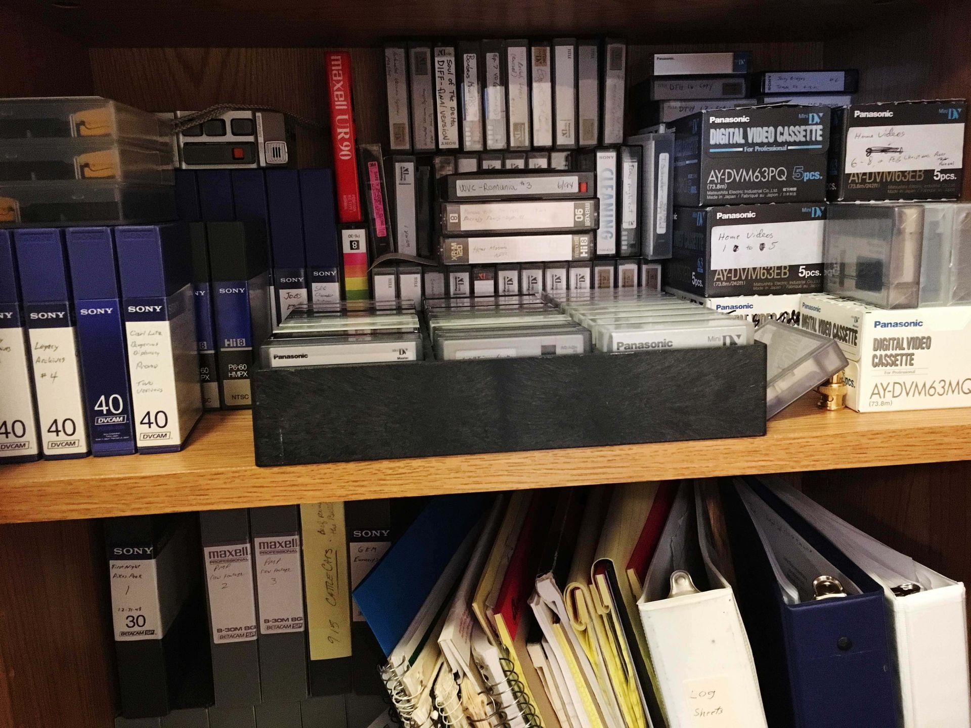 A shelf full of binders and cassette tapes including one that says 40