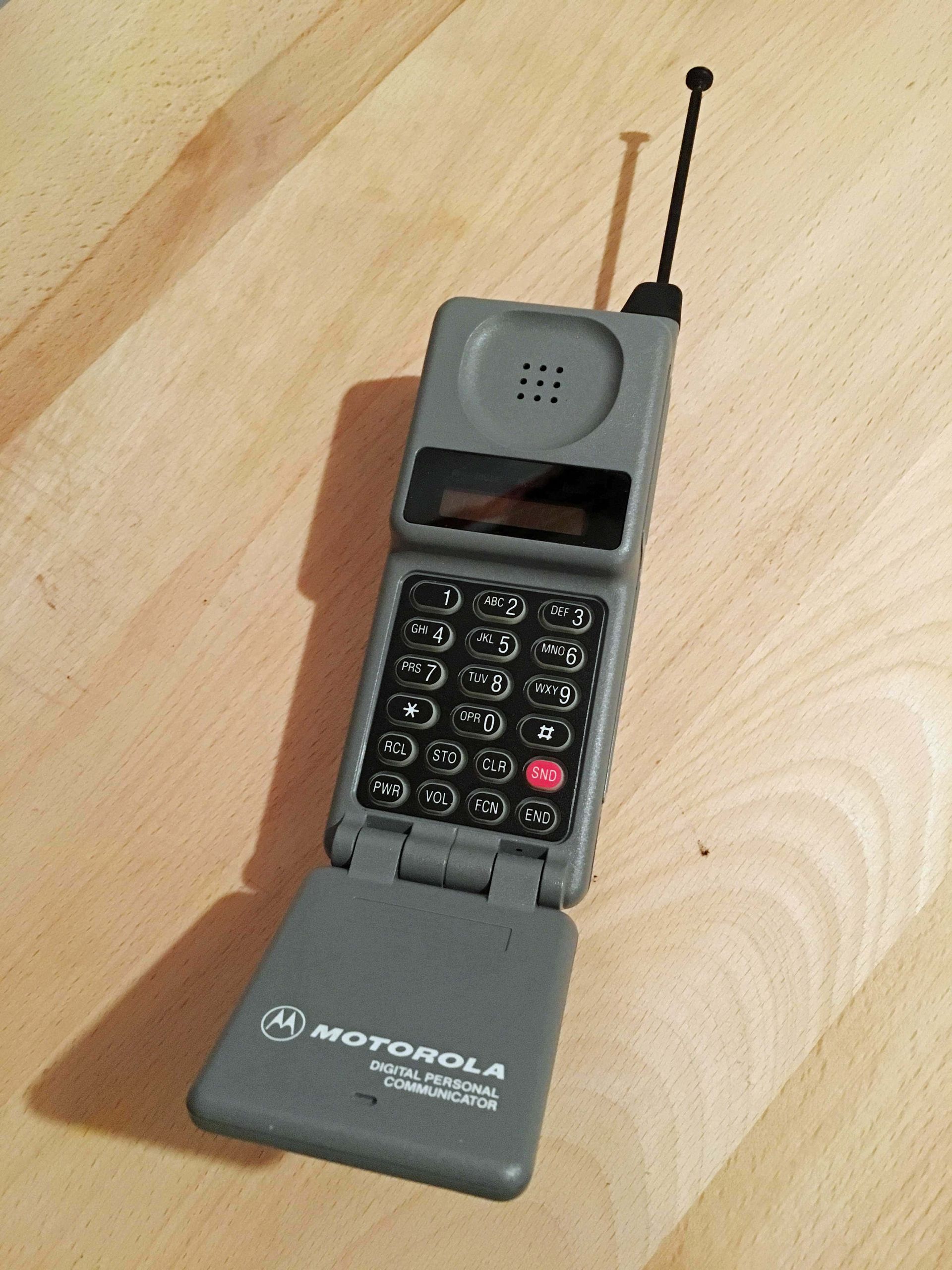 A motorola flip phone is sitting on a wooden table
