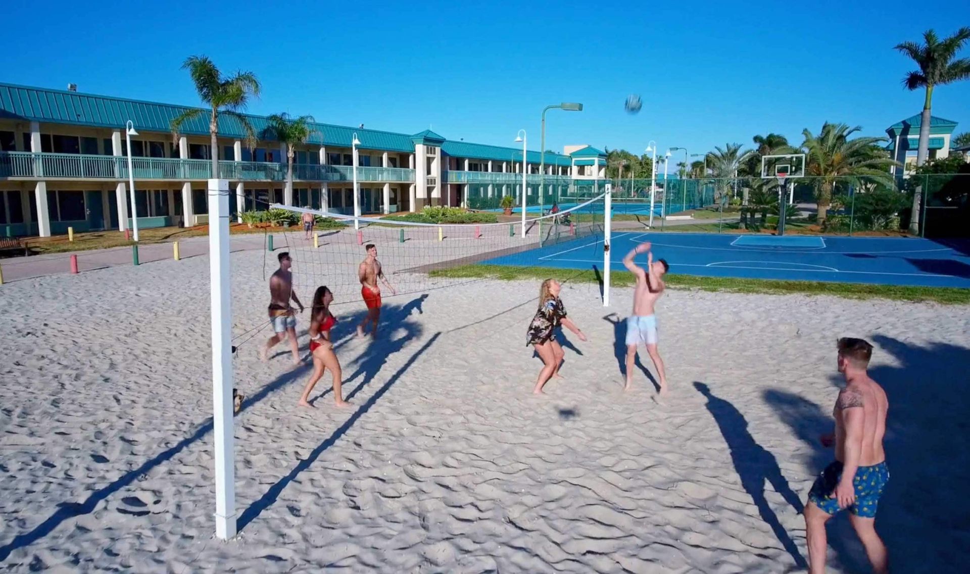 A group of people are playing volleyball on a beach