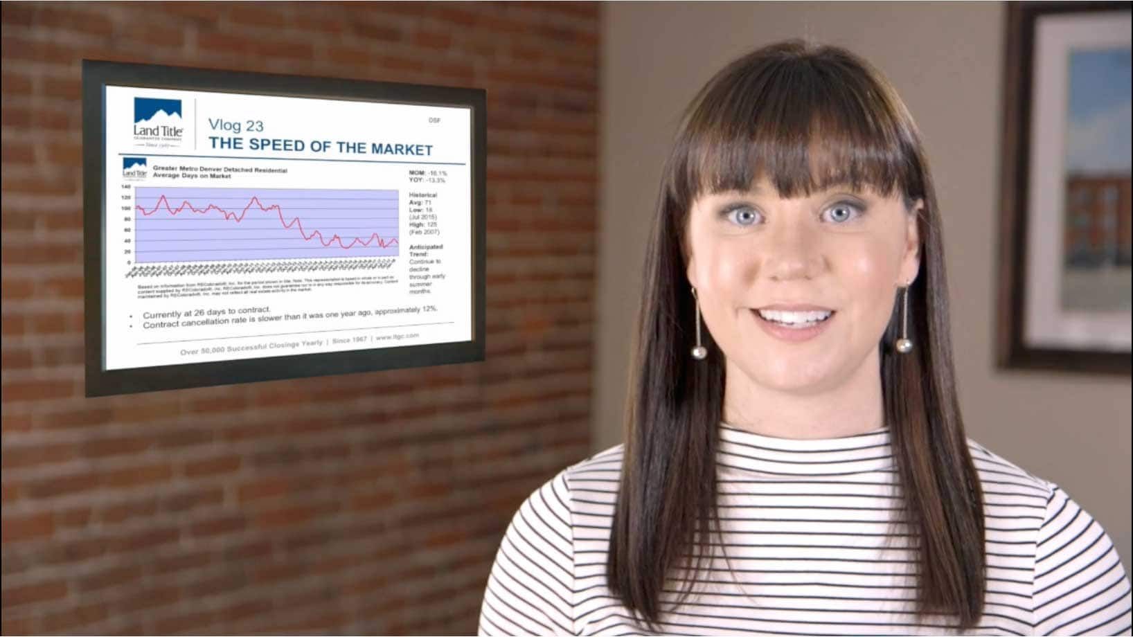 A woman is standing in front of a screen with a graph on it.