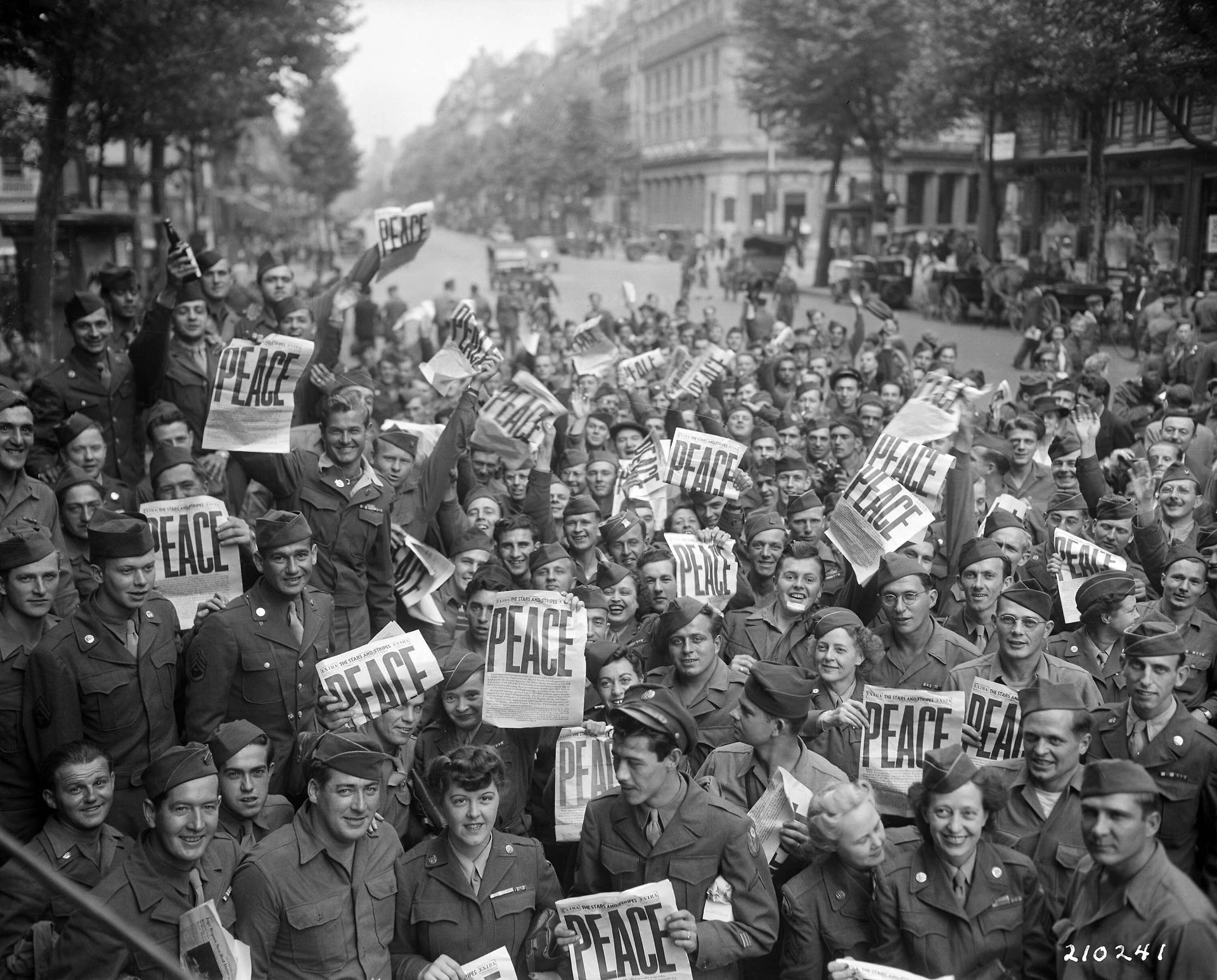 A large group of people are holding signs that say peace