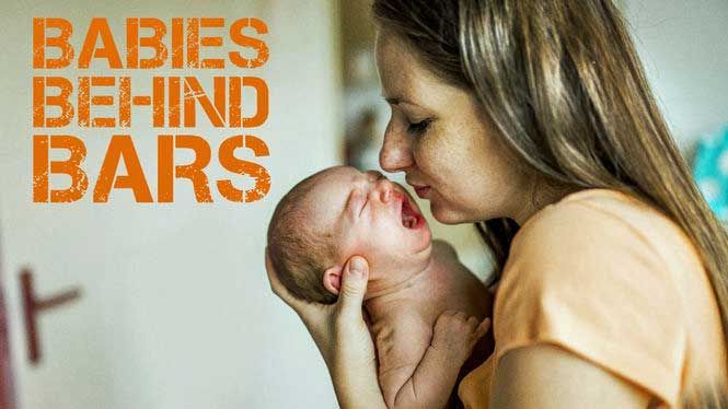 A woman is holding a crying baby in her arms.