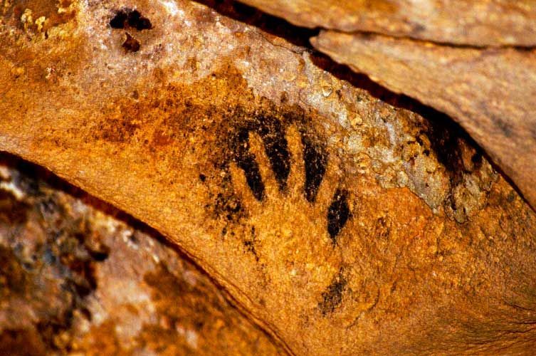 A hand print on a rock in a cave.