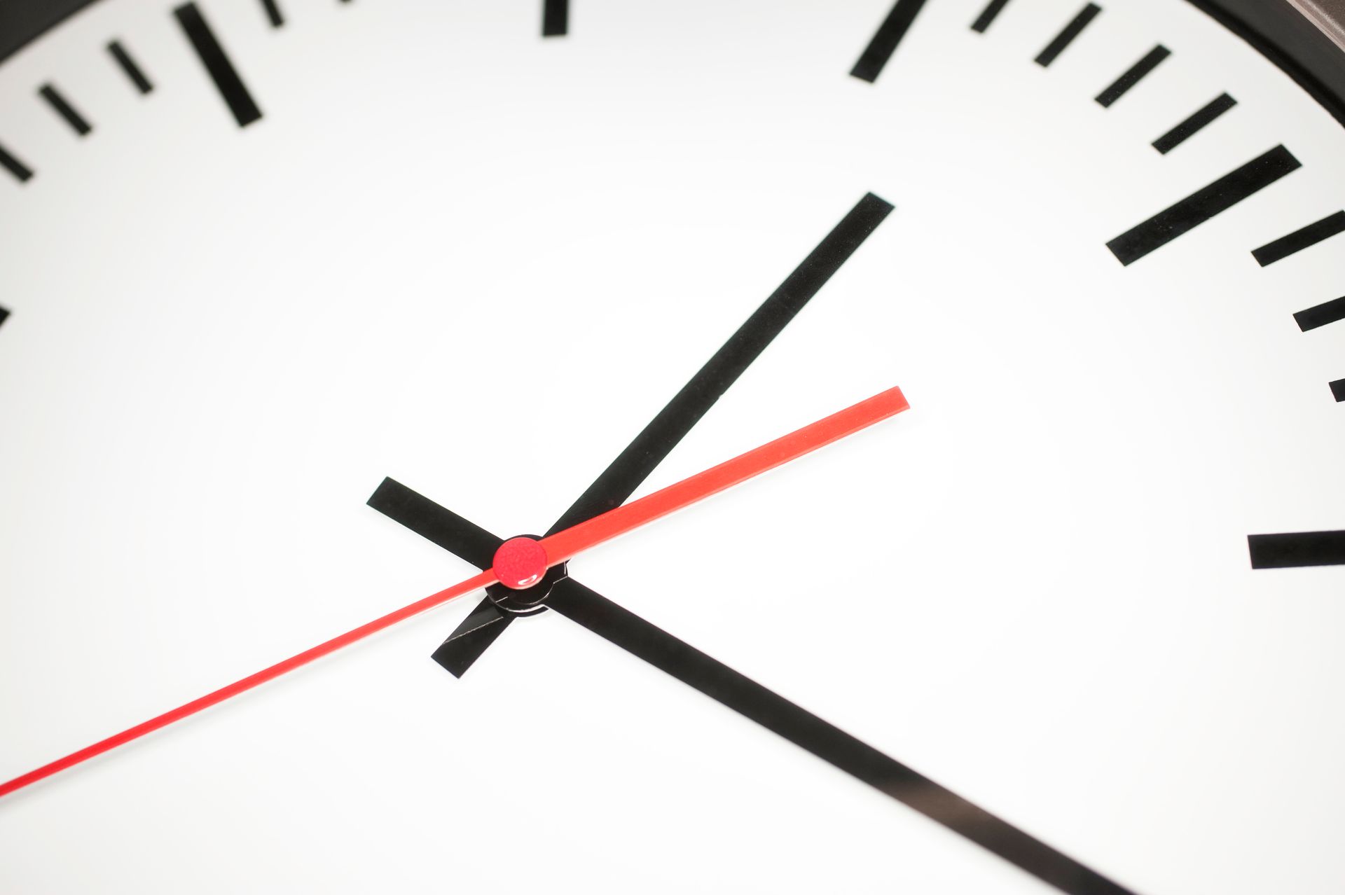 A close up of a clock with a red second hand