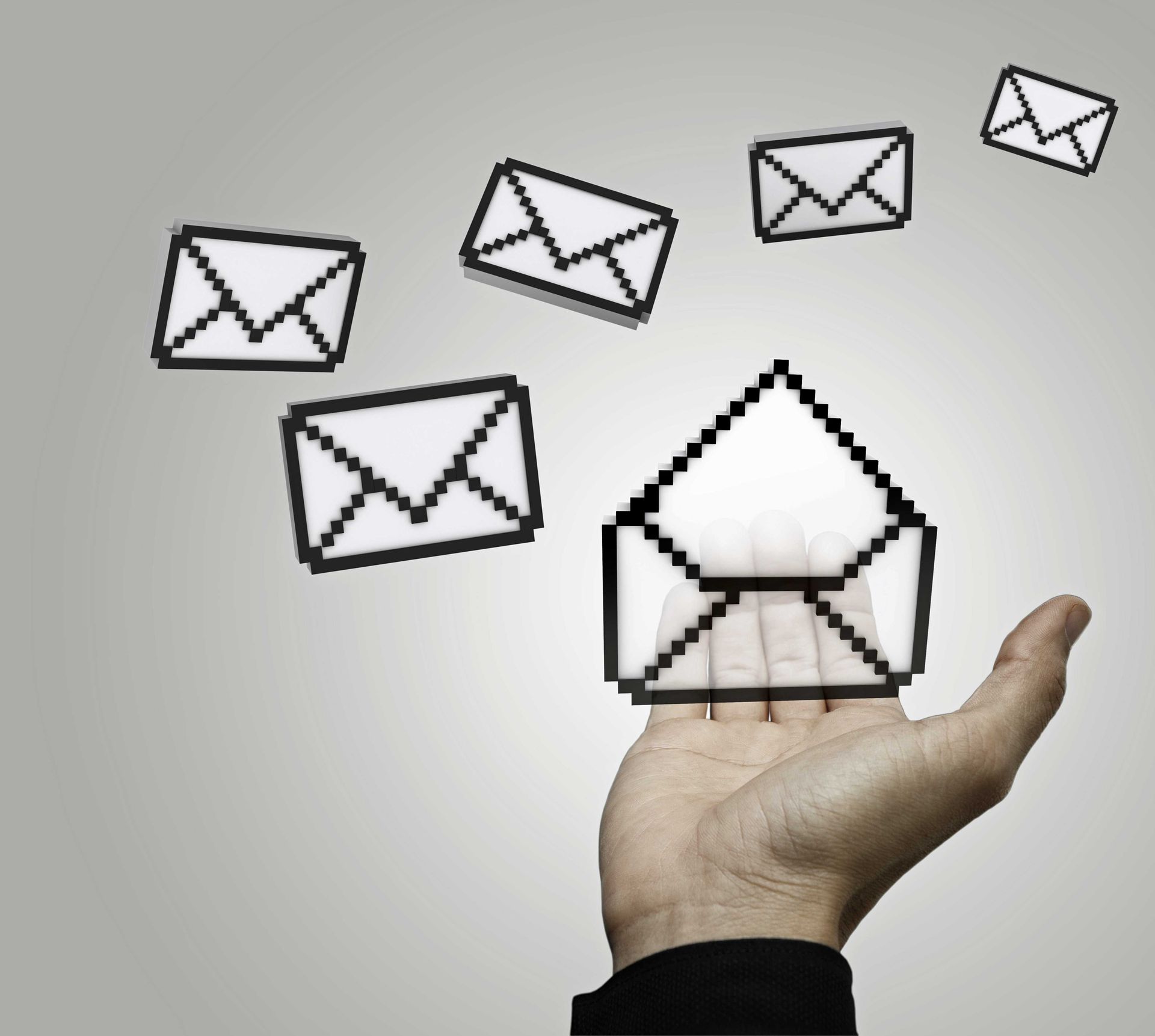 A hand is holding an envelope with letters coming out of it